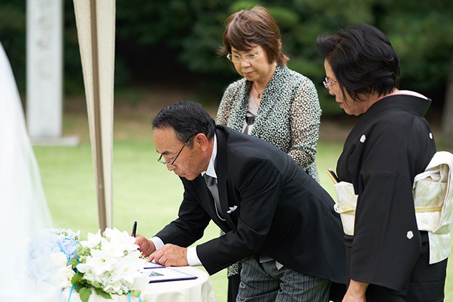 香川県高松市の家族婚の会場、栗林公園。ガーデンで人前式。立会人代表が結婚証明書に署名する。家族婚の人前式の演出