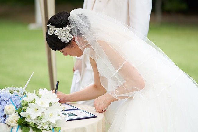 香川県高松市の家族婚の会場、栗林公園。ガーデンで人前式。新郎新婦が結婚証明書に署名する。家族婚の人前式の演出
