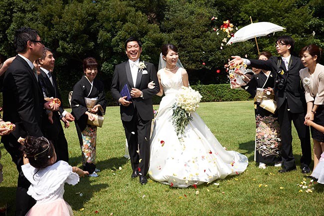 家族婚の人前式の演出。香川県高松市の家族婚の会場、栗林公園。ガーデンで人前式。出席者が花びらをまいてふたりを祝福する「フラワーシャワー」